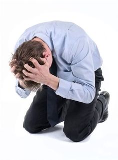 a man kneeling down with his head in his hands