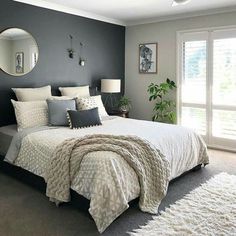 a bedroom with gray walls and white bedding