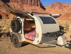 an off road camper parked in the desert with its bed pulled up to it's side