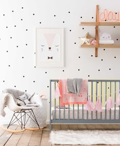 a baby's room with polka dot wallpaper