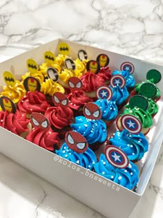 the cupcakes in the box are decorated like captain america