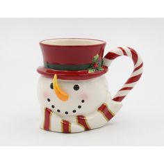 a snowman mug with a top hat and candy canes on the bottom, sitting in front of a white background