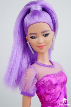 a barbie doll with purple hair wearing a pink dress and silver earring on her head