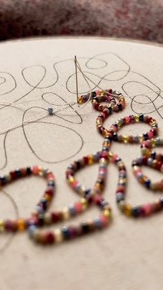 bead work being made on a table with scissors and beads in the shape of an oork