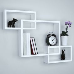 a white shelf with some books and a clock on it