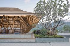 a large wooden structure sitting next to a tree