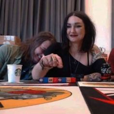 two women sitting at a table with coffee cups