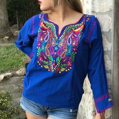 Look Fan-Tas-Tic In This Stunning Mexican Blouse! Embroidered With A Vibrant, Colorful Peacock Design, This Beauty Will Make Heads Turn. Plus, It's Tailored With A Comfy V-Neck, 3/4 Sleeves, And Tassels, All Crafted With A Breathable Cotton Blend And Matching Accents For A Poppin' Look. Make 'Em Quack In Envy! Photos Shown Are A Representation Of The Blouse You Will Receive, Fabric Color Is The Same But Embroidery Color Or Design May Vary. This Is Because Each Blouse Is Individually Handmade Whi Casual Blue Embroidered Tops, Blue V-neck Top With Floral Embroidery, Blue Embroidered Spring Tops, Spring Embroidered Blue Tops, Blue Embroidered Tops For Spring, Blue Bohemian Cotton Tops, Bohemian Blue Cotton Tops, Blue Cotton Bohemian Tops, Blue Floral Embroidery Top For Vacation