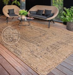 a living room area with wicker furniture and plants on the floor, in front of a large window