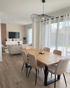 a dining room table with chairs and a television on the wall