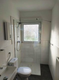 a bathroom with a toilet, sink and shower stall in it's own area