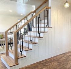 the stairs in this house are made of wood and wrought iron, with white painted walls