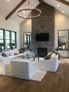 a living room with two white couches and a fireplace