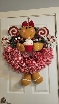 a door hanger decorated with candy canes and a teddy bear