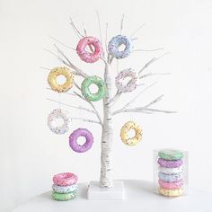 a white tree with donuts on it next to some doughnuts