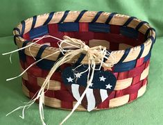 a basket with an american flag design on the front and sides, tied to a green background