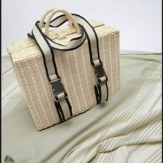 Picnic Basket Style Bag. Woven Exterior. Tube Handles And Fabric Handles With Metal Buckle To Secure Table Cloth. Lined Interior. Button Closure. Height X Length X Width: 11.9x15.6x6.9 Inches (30.2x39.5x17.5cm) Natural / 6893/710 Included Table Cloth Chic Straw Bag For Spring Picnic, Chic Spring Straw Bag For Picnic, Chic Beige Straw Bag For Picnic, Chic Natural Color Bags For Picnic, Rectangular Beige Straw Bag For Day Out, Beige Bag With Adjustable Strap For Picnic, Chic Tote Shoulder Bag For Picnic, Chic Tote Bag For Picnic, Trendy Rectangular Shoulder Bag For Picnic