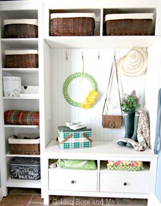 a white bookcase with baskets and other items on it