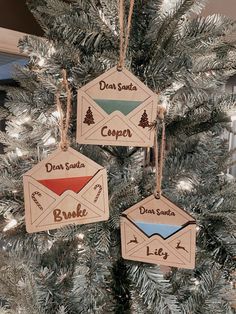 three wooden ornament hanging from a christmas tree with the words dear santa, camper, and love written on them