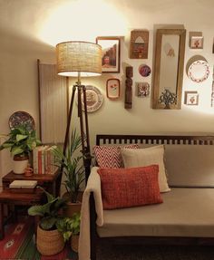 a living room filled with lots of furniture and pictures on the wall next to a lamp