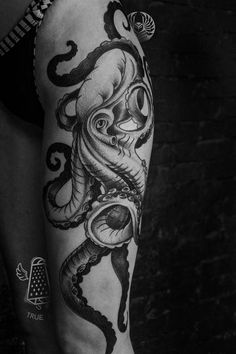 a black and white photo of a woman's arm with an octopus tattoo on it