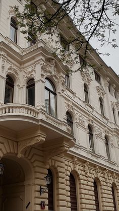 a large white building with lots of windows and balconies on the top floor