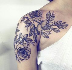 a woman's shoulder with flowers and leaves on it