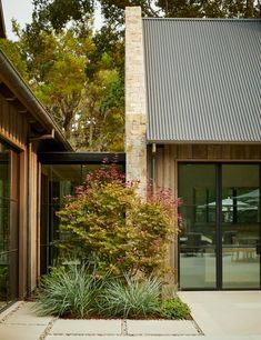 a house that has some plants in front of it and glass doors on the outside