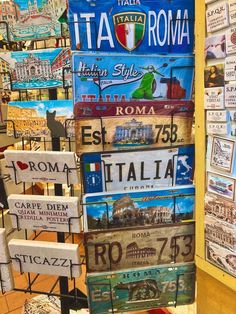 many signs are stacked on top of each other in front of a wall with buildings