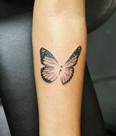 a small butterfly tattoo on the arm