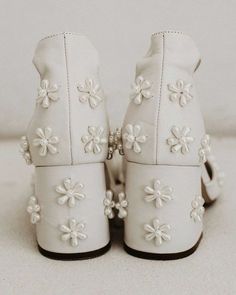 a pair of white shoes with flowers on them