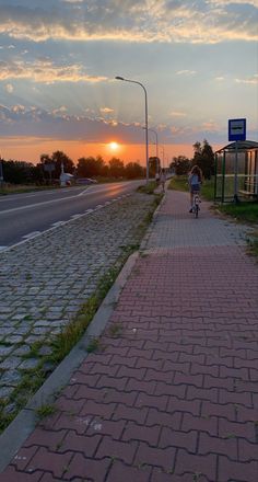 a person riding a bike down a sidewalk