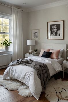 a bedroom with a bed, nightstands and pictures hanging on the wall above it