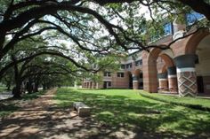 an old brick building is surrounded by trees and grass