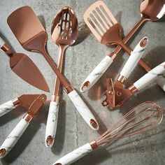 a group of kitchen utensils sitting on top of a table next to each other