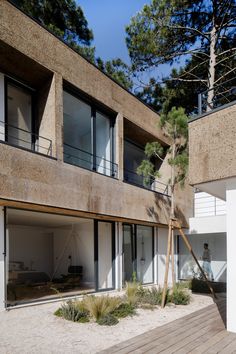 an apartment building with wooden decking and large sliding doors leading to the upper level