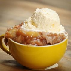 a yellow bowl filled with ice cream on top of a wooden table