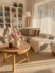 a living room filled with furniture and a large window covered in white sheer curtaines