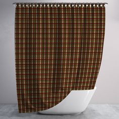 a brown and red plaid shower curtain hanging on a bathroom wall next to a toilet