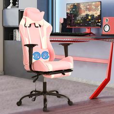 a pink computer chair sitting in front of a desk with a monitor and speakers on it