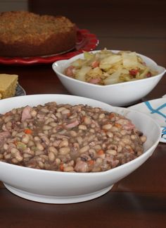 three bowls filled with beans and vegetables next to a pie on a table, ready to be eaten