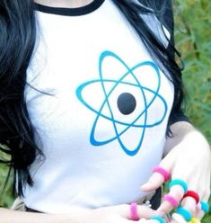 a woman with long black hair wearing a white t - shirt and colorful bracelets