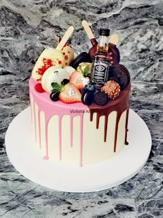 there is a cake that has chocolate and fruit on the top with sauce dripping down it