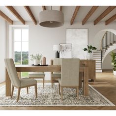 a dining room table with chairs and a rug on the floor