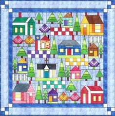 a quilted wall hanging with houses and trees in the middle, on a blue background