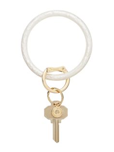 a white keychain with a gold ring and two keys hanging from the end