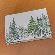 a card with trees drawn on it sitting on a table