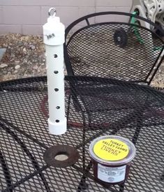 a can of paint sitting on top of a metal table next to a white pipe