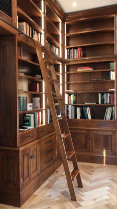 a ladder leaning up against a bookshelf in a room filled with wooden shelves