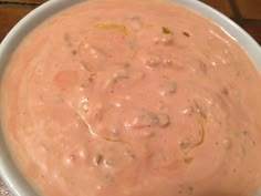 a white bowl filled with sauce on top of a wooden table